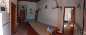 a kitchen with a wooden table and a refrigerator at Alojamiento covadonga in La Riera