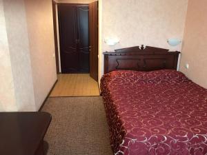 アナパにあるАтриум гостевой домの赤いベッドと黒いドアが備わるベッドルーム1室が備わります。