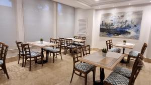un restaurante con mesas, sillas y una pintura en Hotel Gran Legazpi, en Madrid