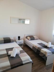 una camera da letto con due letti e una finestra di Apartments Klanac a Zara (Zadar)