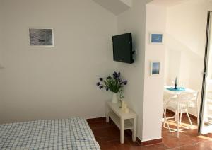 a bedroom with a bed and a table and a tv at Apartments Issa in Makarska