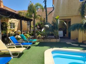 a pool with chaise lounge chairs next to a building at Casa Mestre in Vila do Bispo