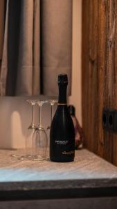 una bottiglia di vino seduta accanto a due bicchieri di vino di Apartment, historic Chalet & Guest House Neuhaus a San Sigismondo