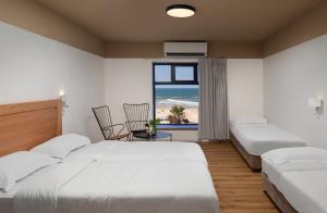 a bedroom with two beds and a view of the beach at 180 Boutique Hostel in Tel Aviv