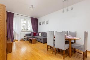 een woonkamer met een tafel en een bank bij Atrium Ursus Warsaw Apartments by Renters in Warschau