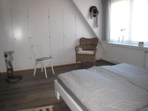 a bedroom with a bed and a chair and a window at Pumuckl in Husum