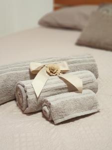 due asciugamani su un letto con un nastro di Camera matrimoniale Casa Del Sole a Tuglie
