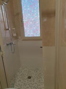 bagno con doccia e finestra di Camera matrimoniale Casa Del Sole a Tuglie