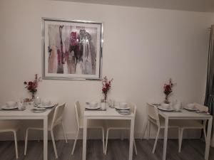 a dining room with white tables and white chairs at Glenbeg Lodge B&B in Rathdrum