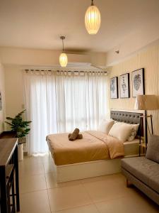 a bedroom with a bed and a couch at Cozy @ Cool in Tagaytay