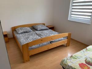 ein Schlafzimmer mit einem Holzbett mit zwei Kissen darauf in der Unterkunft W apartmán in Teplice nad Metují