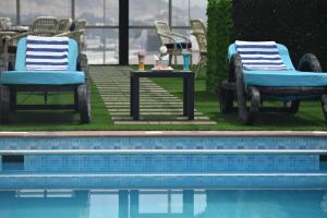 two chairs and a table next to a pool at Jeddah Oasis Hotel in Jeddah