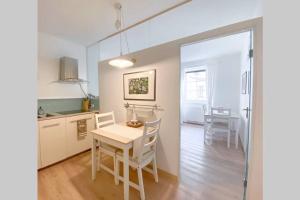 a kitchen and dining room with a table and chairs at In Urbi, city appartement in Bressanone
