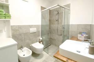 a bathroom with a shower and a toilet and a sink at In Urbi, city appartement in Bressanone