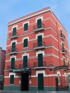 ナポリにあるHotel Villa Mariaの赤い建物(バルコニー付)