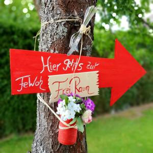 una señal pegada a un árbol con flores en FreiRaum en Obersinn