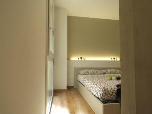 um pequeno quarto com uma cama com uma luz sobre ela em Ariosti Apartment em Bolonha
