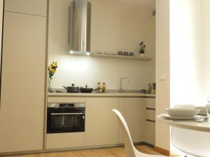 uma pequena cozinha com um fogão e um lavatório em Ariosti Apartment em Bolonha