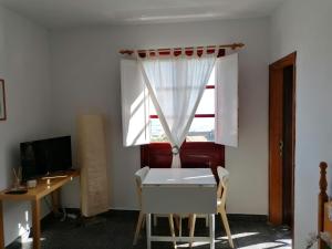 a room with a table and a desk and a window at ApartamentosPlaya_Hermigua in Hermigua
