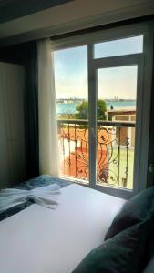 a bedroom with a bed and a window with a balcony at Cape Palace Hotel in Istanbul