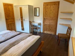 a bedroom with a bed and a table with a chair at Unser Dahoam in Wallgau