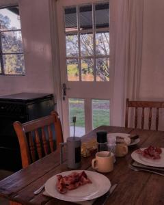 a wooden table with two plates of food on it at The Old Mushroom Farm in Howick