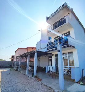 a white house with a balcony and a table and chairs at Apartments DEA in Bar