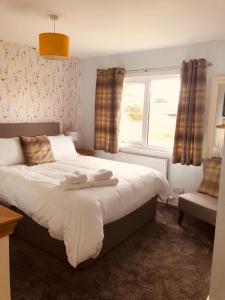 a bedroom with a bed with two towels on it at Linne Lodge in Tain