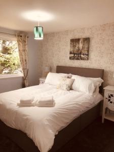 a bedroom with a bed with two towels on it at Linne Lodge in Tain