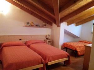 モルヴェーノにあるcasa LUCIANERのベッドルーム1室(オレンジのシーツを使用したベッド2台付)