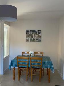 a dining room table with two chairs and a blue table cloth at Le Courancon in Saint-Nectaire