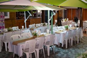 a restaurant with white tables and white chairs and umbrellas at La Cariole in Saint-Pierre