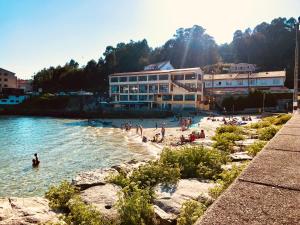 a group of people on a beach in the water at Casa A Codela in Combarro