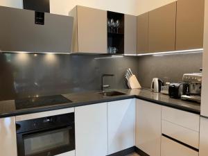 a kitchen with white cabinets and a sink at Luxury twin apartments Opatija in Opatija
