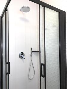 een douche met een glazen deur en een douchekop bij Luxury twin apartments Opatija in Opatija