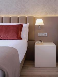 バルセロナにあるムジーク ブティック ホテルのベッドルーム(ベッド1台、白いナイトスタンド付)
