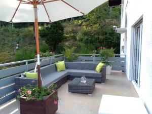a patio with a couch and an umbrella at Hotel Wanderlust B&B in Gernsbach