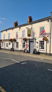 a large white building on the side of a street at The Foresters Arms in Tarporley