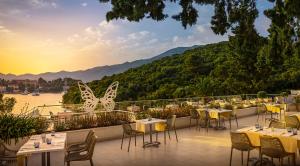 een restaurant met tafels en stoelen op een balkon bij Port 9 Mobile Homes by Aminess in Korčula