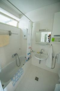 a white bathroom with a tub and a sink and a shower at Apartment in Graz +12 photos
