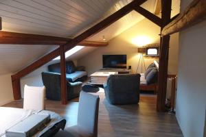 a attic room with a bed and two chairs at Ferme des molieres avec espace détente in Mortagne