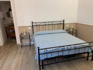 una camera con un letto e due tavolini di DOMUS L’AUREA a La Spezia