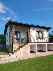 una casa con un balcón en el lateral. en La cabaña de Cortiguera, en Cortiguera