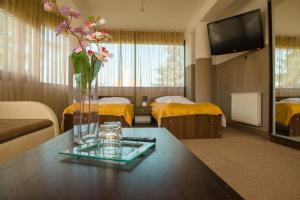 a hotel room with a vase of flowers on a table at Hotel Turkus in Jarosław