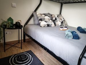 uma cama com almofadas num quarto em Cantinho do Chico em Vila Nova de Gaia