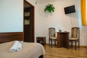 a bedroom with a bed and a table and chairs at Hotel Turkus in Jarosław