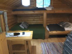 una camera da letto in una baita di tronchi con letto e scrivania di Holiday Cabin Kerimaa 53 a Savonlinna