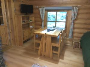 ein Esszimmer mit einem Tisch in einer Blockhütte in der Unterkunft Holiday Cabin Kerimaa 53 in Savonlinna