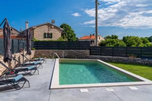 una piscina en un patio con sillas en Villa No.8, en Pazin