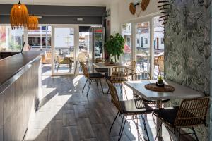 a restaurant with tables and chairs and windows at Hostal Playa de Palma in Playa de Palma